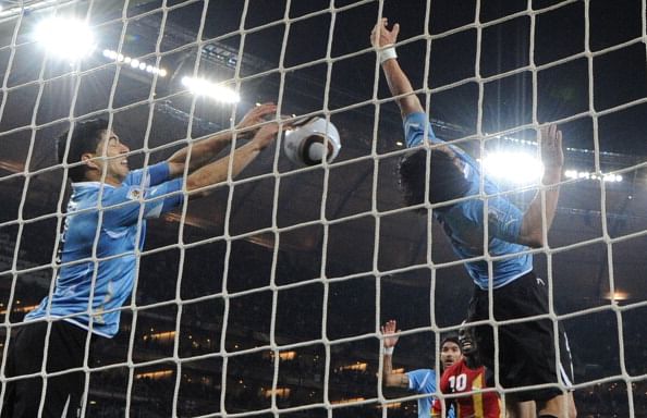 Uruguay's striker Luis Suarez (L) stops the ball with the hand leading to a red card and a penalty for Ghana during the extra-time of 2010 World Cup quarter-final match Uruguay vs. Ghana on July 2, 2010 at AFP Soccer City stadium in Soweto, suburban Johannesburg.